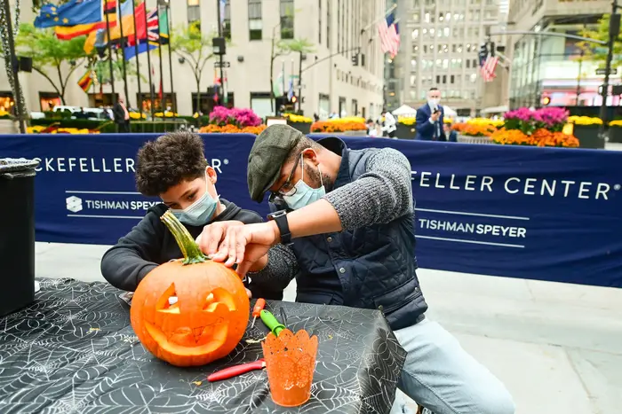 In preparation for Halloween, Sharif Butler and his nephew Chace, 11, carve pumpkins at Rockefeller Center.